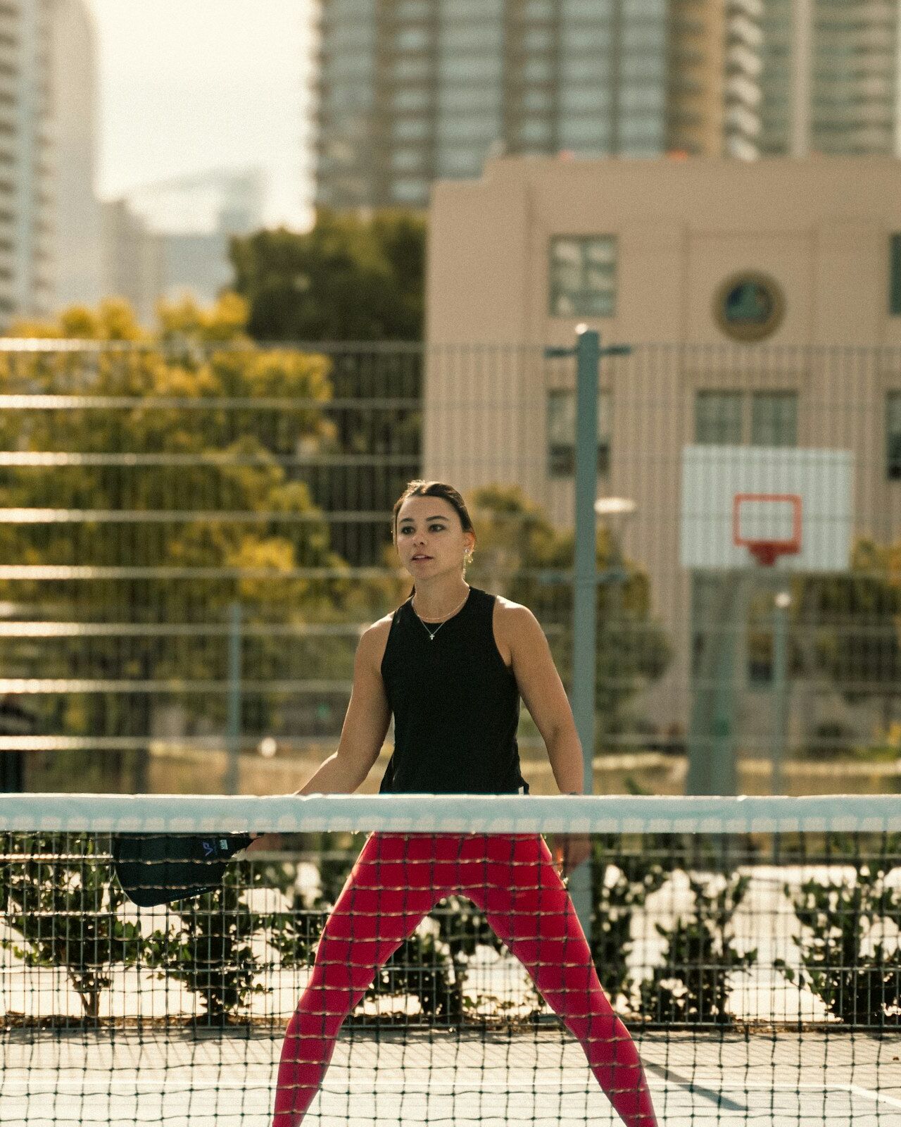 Una jugadora de pickleball devuelve la pelota con la pala junto a la red, en pleno partido
